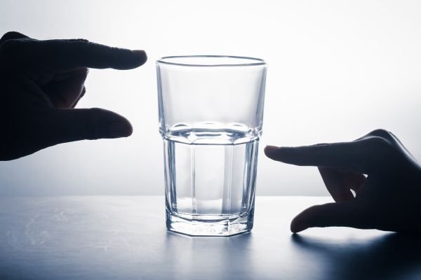 A clear glass filled halfway with water.